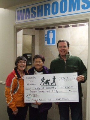 Enderby in Motion representatives present a cheque to Councillor Case for $750 towards accessibility improvements to the Enderby Arena washrooms.