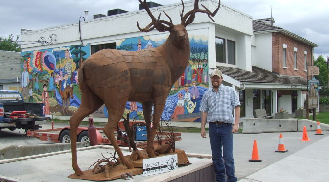 Braden Kiefiuk, artist, alongside his deer sculpture in Enderby